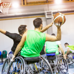 People playing basketball in wheelchairs representing the Sports & Recreation category.