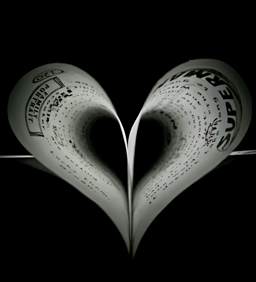 Black and white image of a book with its pages folded to form the shape of a love heart.